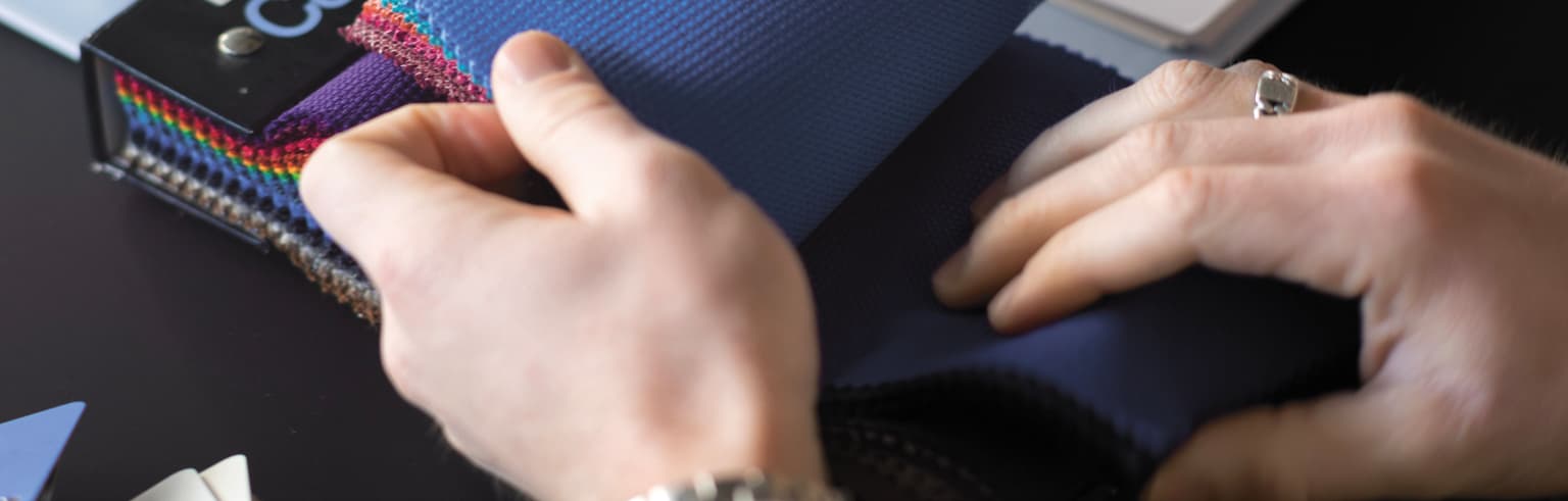 Mannen handen bladeren door stofstalen voor kantoormeubilair.